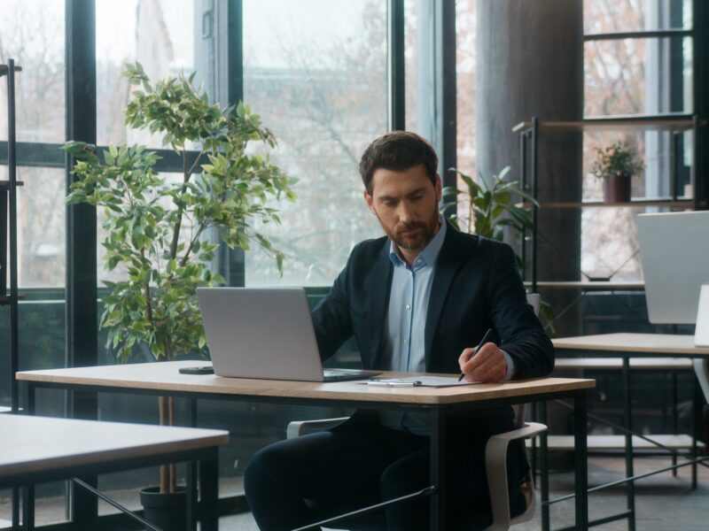 Caucasian,Businessman,Typing,Laptop,In,Office,Writing,Notes,Professional,Manager