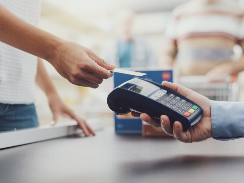 Woman,Purchasing,Food,At,The,Supermarket,And,Paying,With,A